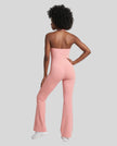 Back view of a model wearing the MotionFlow Halter Jumpsuit in Pink