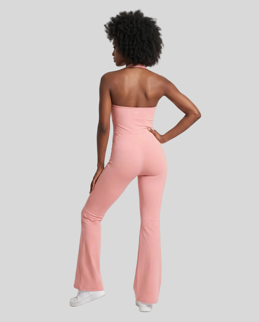Back view of a model wearing the MotionFlow Halter Jumpsuit in Pink