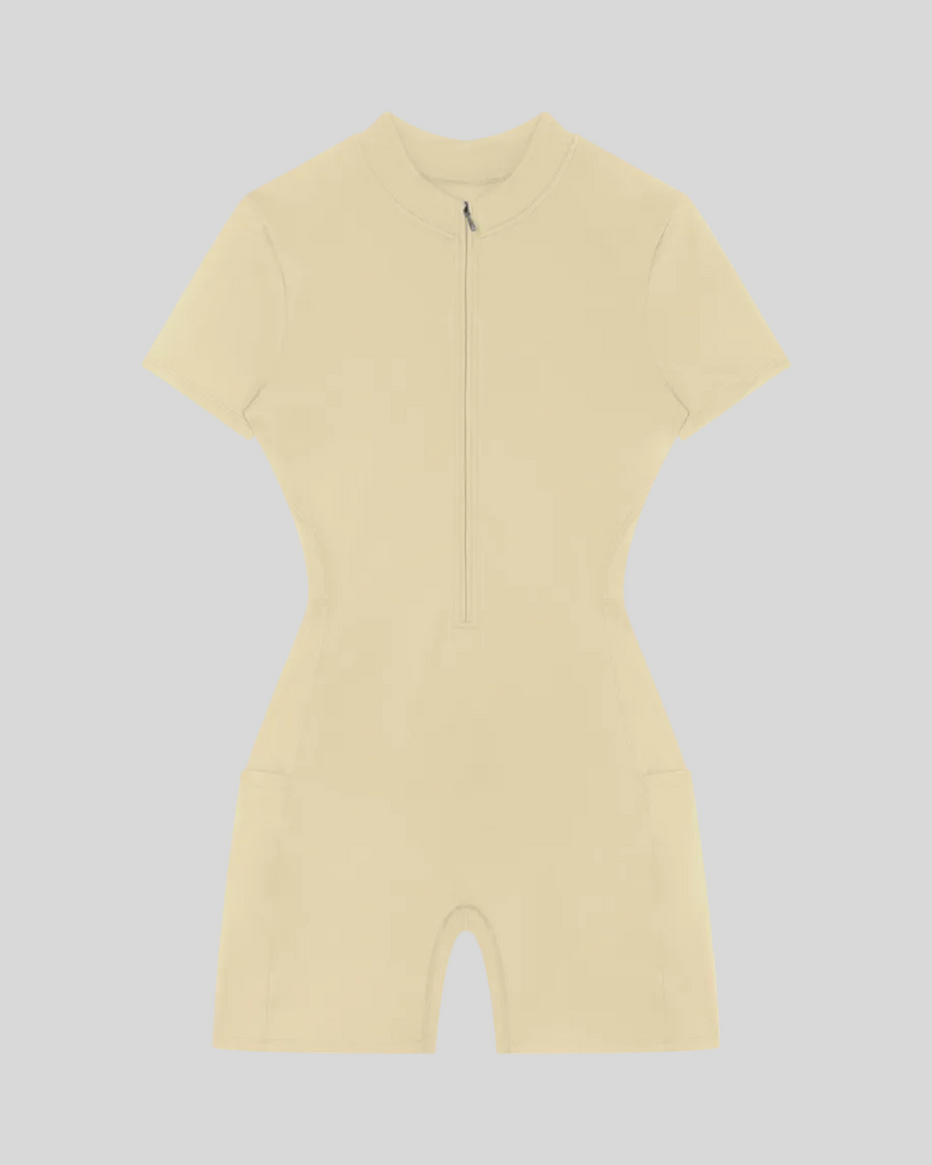 MotionFlow Romper in Apricot front view featuring a mock neck, quarter-zip front, and bermuda-length shorts