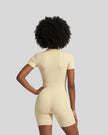 Back view of a model wearing the MotionFlow Romper in Apricot