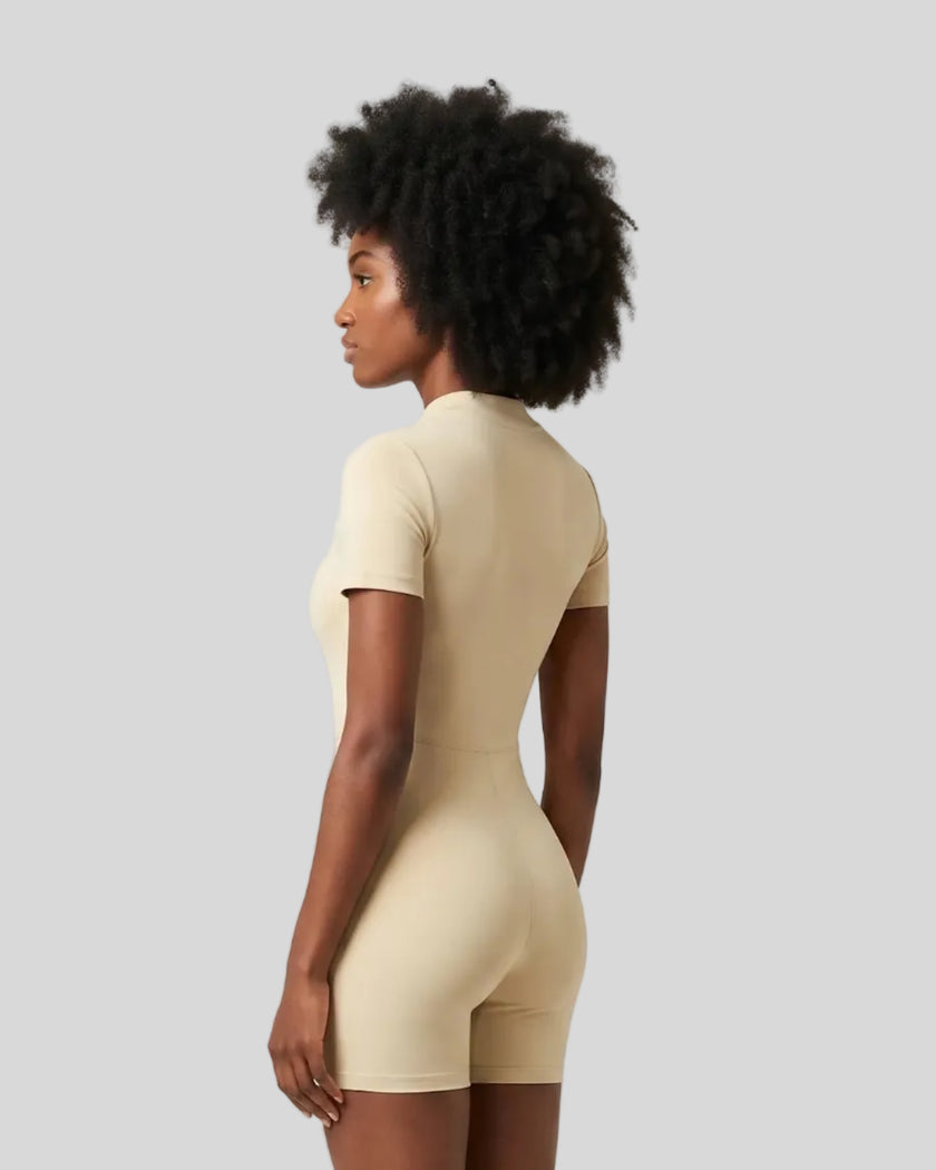 Side view of a model wearing the MotionFlow Romper in Apricot