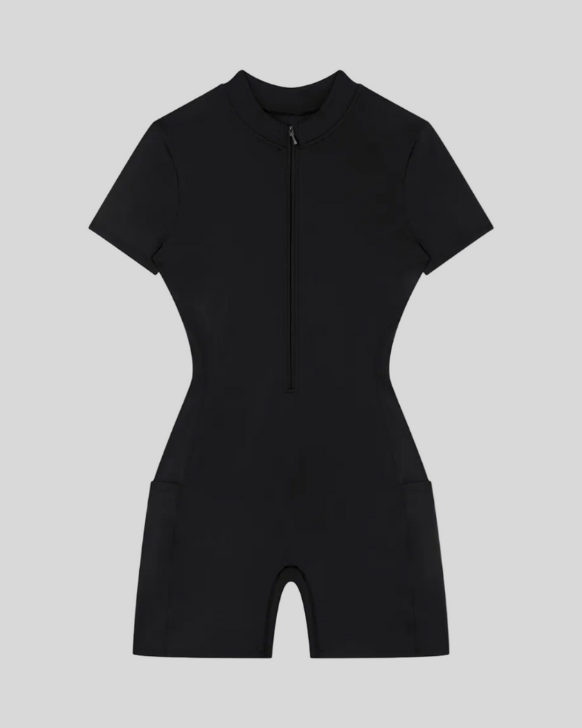 MotionFlow Romper in Black front view featuring a mock neck, quarter-zip front, and bermuda-length shorts