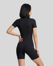 Back view of a model wearing the MotionFlow Romper in Black
