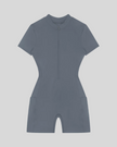 MotionFlow Romper in Gray Blue front view featuring a mock neck, quarter-zip front, and bermuda-length shorts