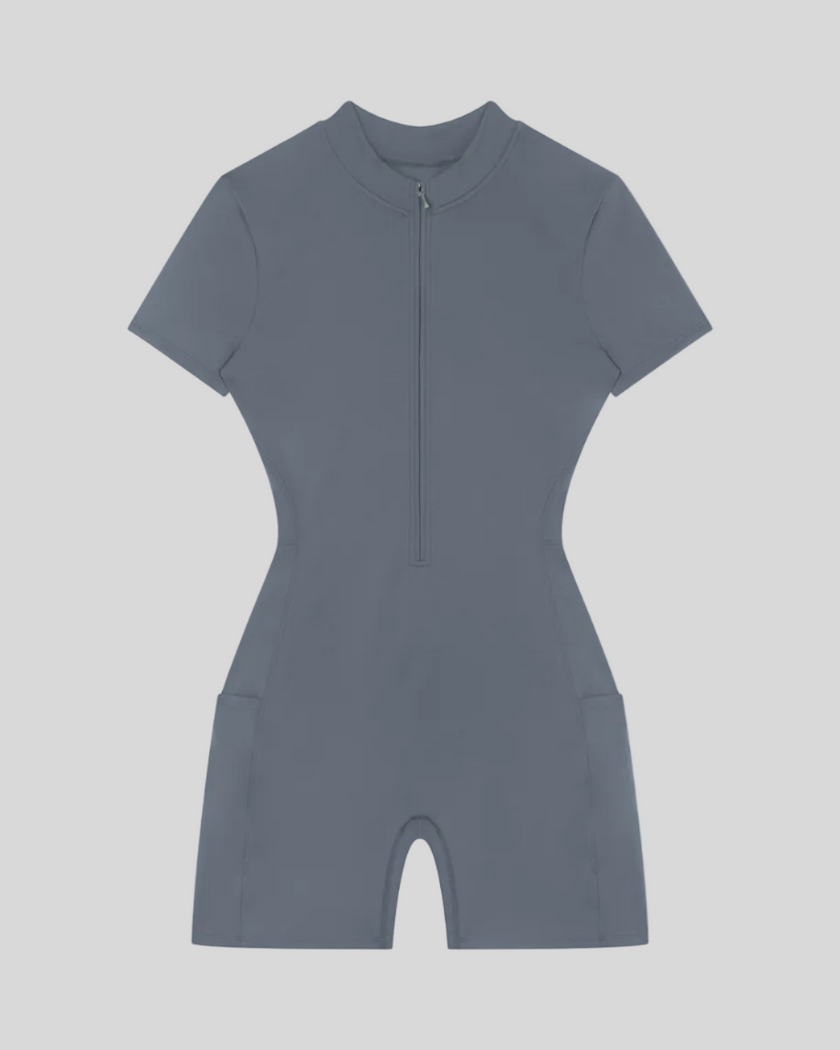 MotionFlow Romper in Gray Blue front view featuring a mock neck, quarter-zip front, and bermuda-length shorts