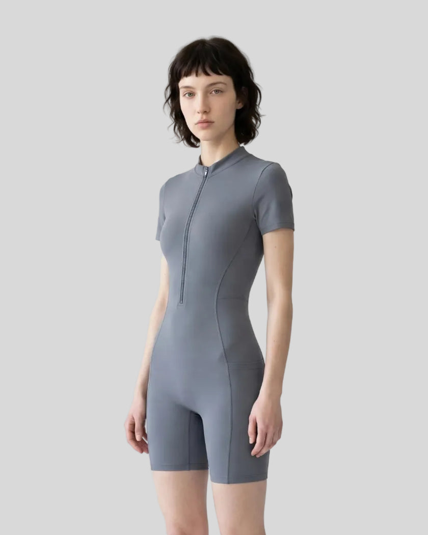Front angled view of a model wearing the MotionFlow Romper in Gray Blue