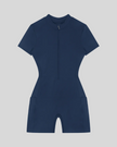 MotionFlow Romper in Navy Blue front view featuring a mock neck, quarter-zip front, and bermuda-length shorts