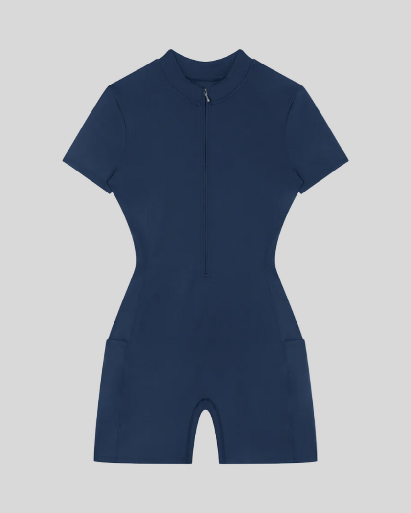 MotionFlow Romper in Navy Blue front view featuring a mock neck, quarter-zip front, and bermuda-length shorts