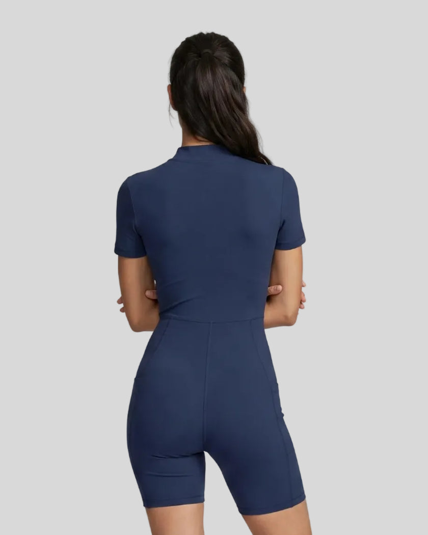 Back view of a model wearing the MotionFlow Romper in Navy Blue