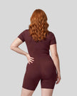 Back view of a model wearing the MotionFlow Romper in Wine Red