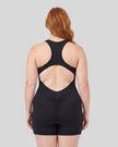 Back view of a model wearing the MotionFlow Yoga Romper in Black
