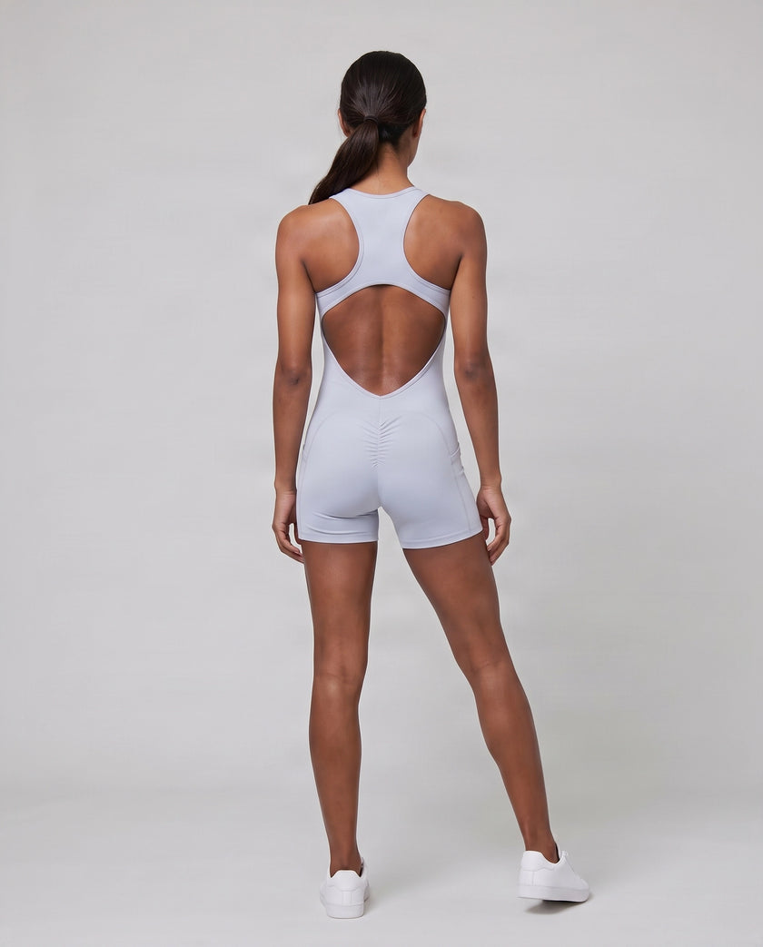 Full body back view of model wearing the MotionFlow Yoga Romper in Purple.