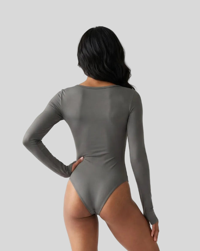 Model wearing the Athlesi MotionForm Long Sleeve Bodysuit in Gray, back view highlighting the smooth fitted silhouette
