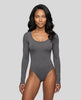 Model wearing the Athlesi MotionForm Long Sleeve Bodysuit in Gray, front view highlighting the U-neckline and fitted silhouette