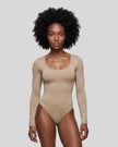 Model wearing the Athlesi MotionForm Long Sleeve Bodysuit in Khaki, front view highlighting the U-neckline and fitted silhouette