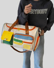 Model carrying MotionPlay Travel Bag on forearm showing structured design and portability