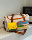 MotionPlay Travel Bag in beige front view on table with color block design and multiple pockets