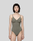 Woman wearing the MotionZip Ruched Bodysuit in Gray, shown from the front with its fitted silhouette and ruched bust