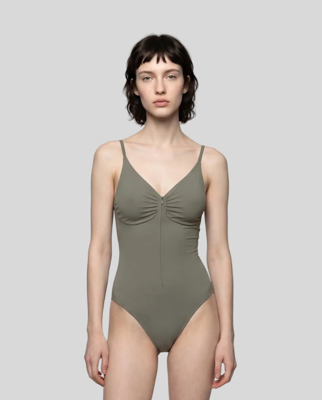 Woman wearing the MotionZip Ruched Bodysuit in Gray, shown from the front with its fitted silhouette and ruched bust