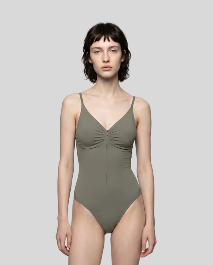 Woman wearing the MotionZip Ruched Bodysuit in Gray, shown from the front with its fitted silhouette and ruched bust