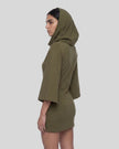A woman in profile wearing an army green hooded Muse Cowl tunic dress with wide three-quarter sleeves