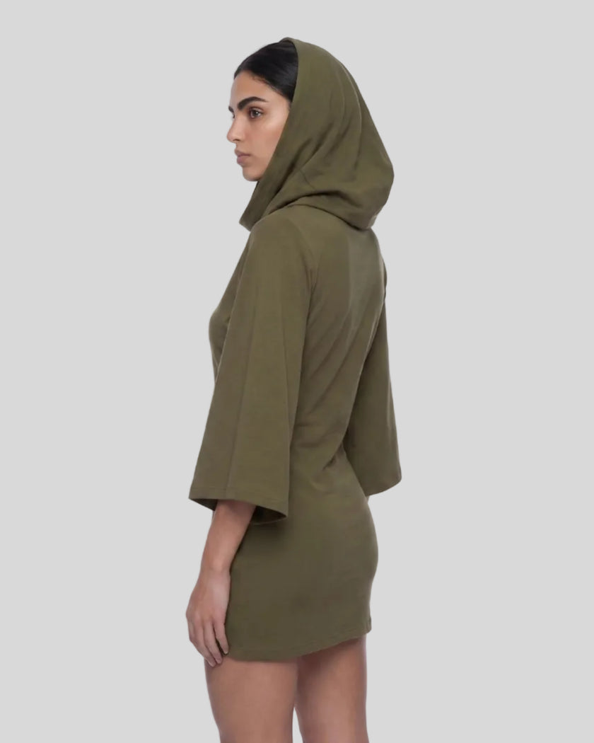 A woman in profile wearing an army green hooded Muse Cowl tunic dress with wide three-quarter sleeves