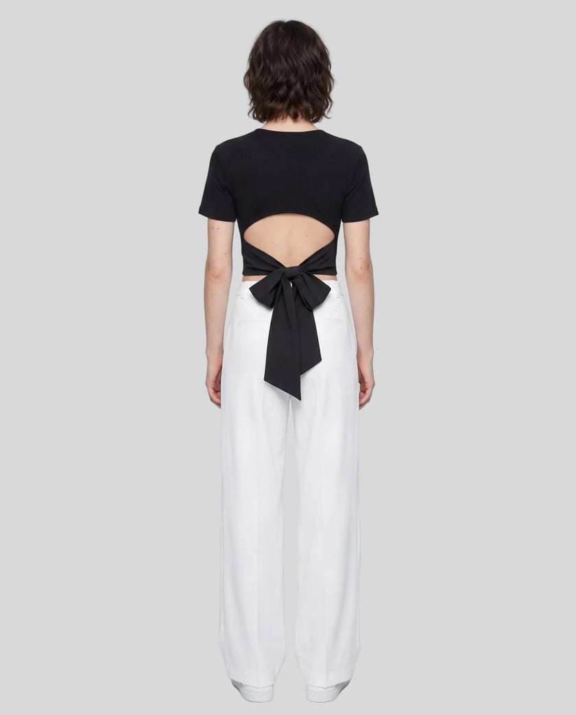 Full body back view of woman wearing Nova Tie-Back Tee with open-back cutout and Black bow