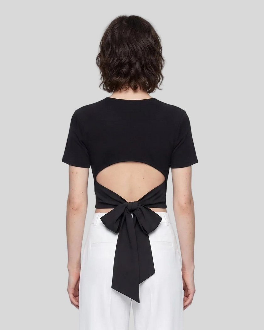 Upper body back view of woman wearing Nova Tie-Back Tee with open-back cutout and Black bow