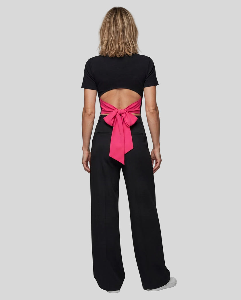Full body back view of woman wearing Nova Tie-Back Tee with open-back cutout and contrasting Rose Red bow