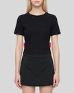 Upper body front view of woman wearing Nova Tie-Back Tee in black and rose red with a fitted cropped silhouette
