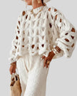 Open-weave cable knit sweater in white showing textured knit detail, front angle