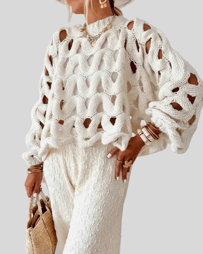 Open-weave cable knit sweater in white showing textured knit detail, front angle