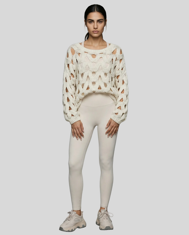 Full body front view of woman wearing white OpenWeave Cable Sweater with ivory leggings