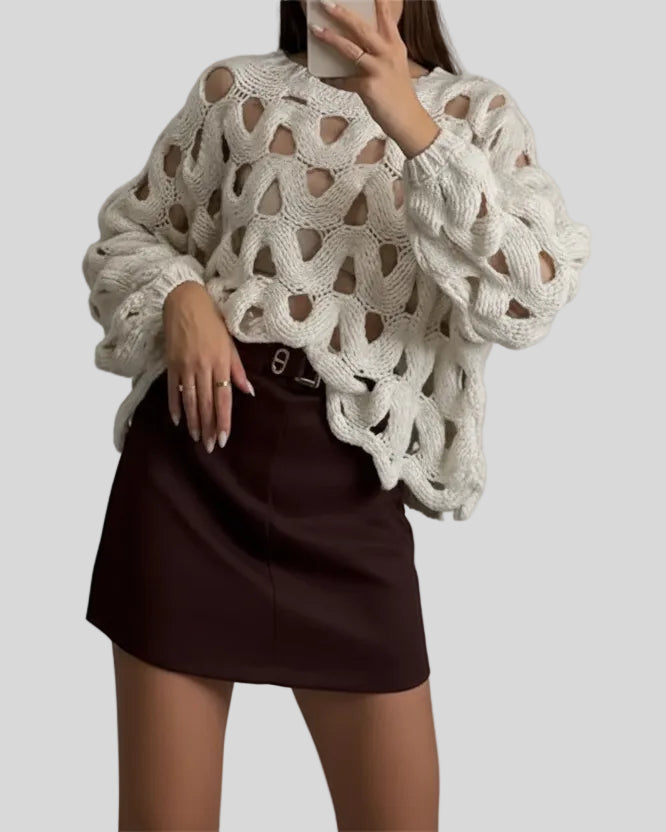 Open-weave cable knit sweater in white showing subtle sheerness, front angle