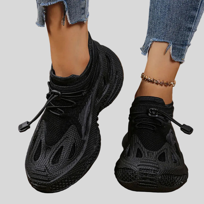 Close-up of black mesh sneakers highlighting texture, ventilation, and sculpted sole details