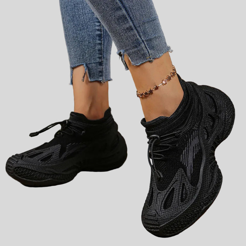 Side angled view of black mesh sneakers highlighting dynamic shape and layered design