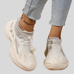 Front and side angled view of white mesh sneakers highlighting dynamic shape and layered design