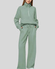 Woman wearing Athlesi PureMotion Half-Zip Lounge Set in green, front full body view