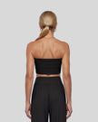 Model wearing the Athlesi QuietForm Ruched Tube Top in Black, mid-body back view showing the clean strapless silhouette.