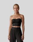Model wearing the Athlesi QuietForm Ruched Tube Top in Black, mid-body front view.