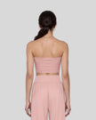 Model wearing the Athlesi QuietForm Ruched Tube Top in Pink, mid-body back view showing the clean strapless silhouette.
