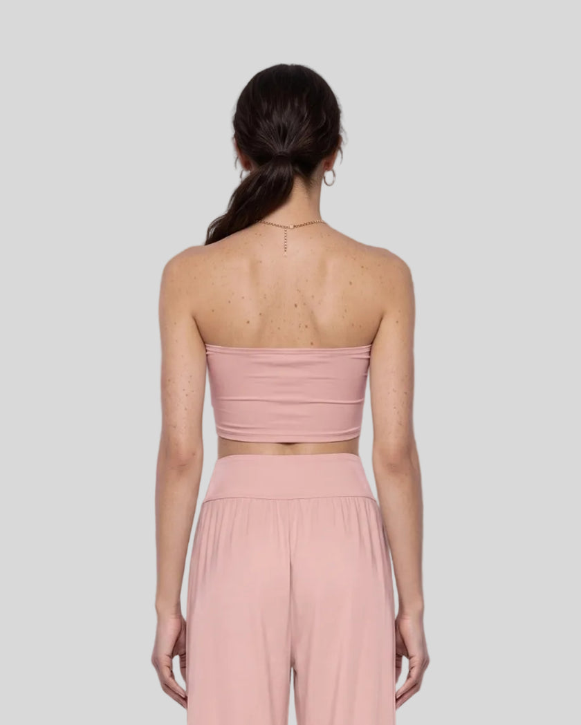 Model wearing the Athlesi QuietForm Ruched Tube Top in Pink, mid-body back view showing the clean strapless silhouette.