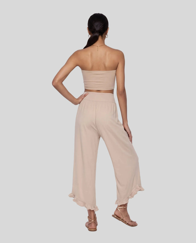 Model wearing Athlesi QuietForm Wide Leg Pants in Pale Khaki, back view highlighting the wide waistband and relaxed silhouette