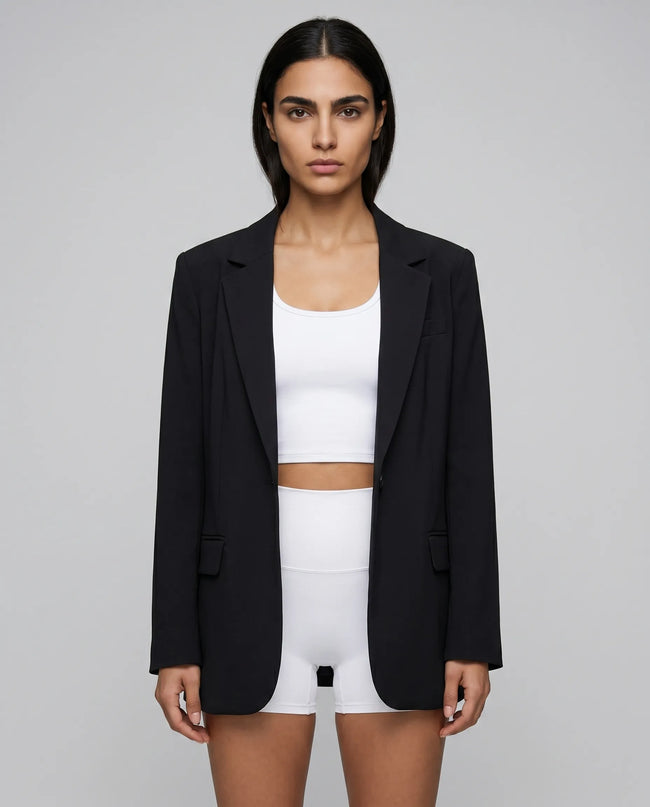 Woman wearing a beige RefineForm Blazer over a white top and white shorts for a studio to errands outfit transition