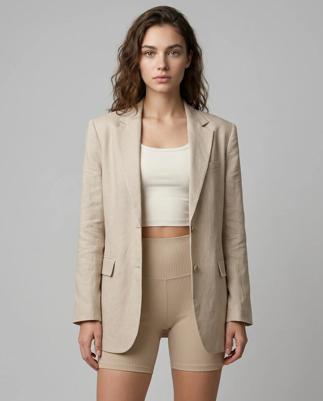 Woman wearing a beige RefineForm Blazer over a white top and beige shorts for a studio to errands outfit transition