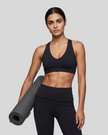 Mid body front view of woman wearing Sculpt Halter Sports Bra in black