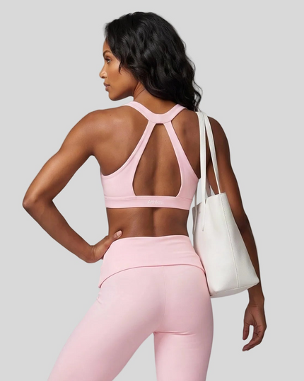 Mid body back view showing the open-back design of Sculpt Halter Sports Bra in pink