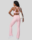 Back view of a woman modeling a pink Athlesi activewear set consisting of a Sculpt Yoga Pants and matching Sculpt Halter Sports Bra