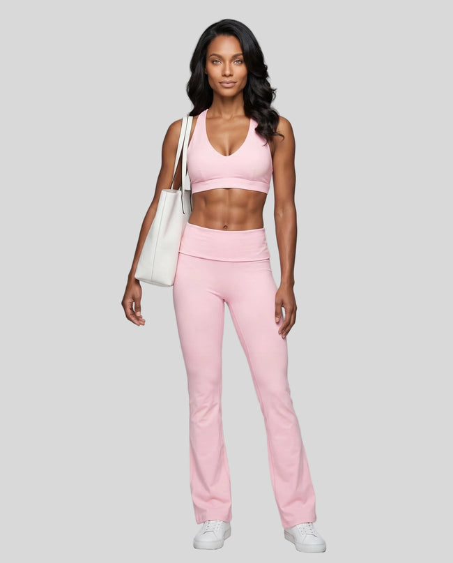 Full body front view of woman wearing Sculpt Yoga Pants with matching Sculpt Halter Sports Bra in pink.