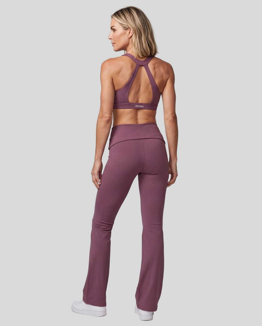 Back view of a woman modeling a plum purple Athlesi activewear set consisting of a Sculpt Yoga Pants and matching Sculpt Halter Sports Bra